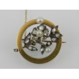 A yellow metal, diamond, and pearl set floral brooch, in a yellow metal circular mount,