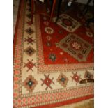 A red ground Kazak carpet, decorated with a three pole medallion to centre on a geometric floral