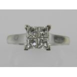 An unusual white metal and diamond engagement ring, set four square cut diamonds,