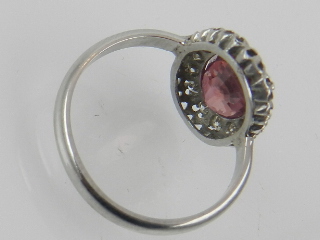 A platinum, ruby and diamond cluster ring, set large central stone surrounded by small diamonds, - Image 2 of 2