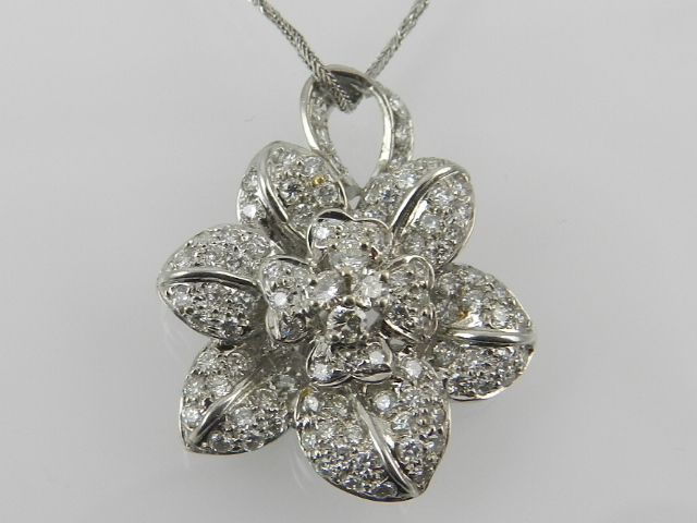 A white metal and diamond floral cluster pendant, set numerous small diamonds,