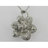 A white metal and diamond floral cluster pendant, set numerous small diamonds,