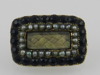 A yellow metal, split seed pearl, and faceted black jet Momento Mori brooch,