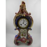 A Continental porcelain mantle clock, of blue and pink, decorated with flowers, having a Roman dial.