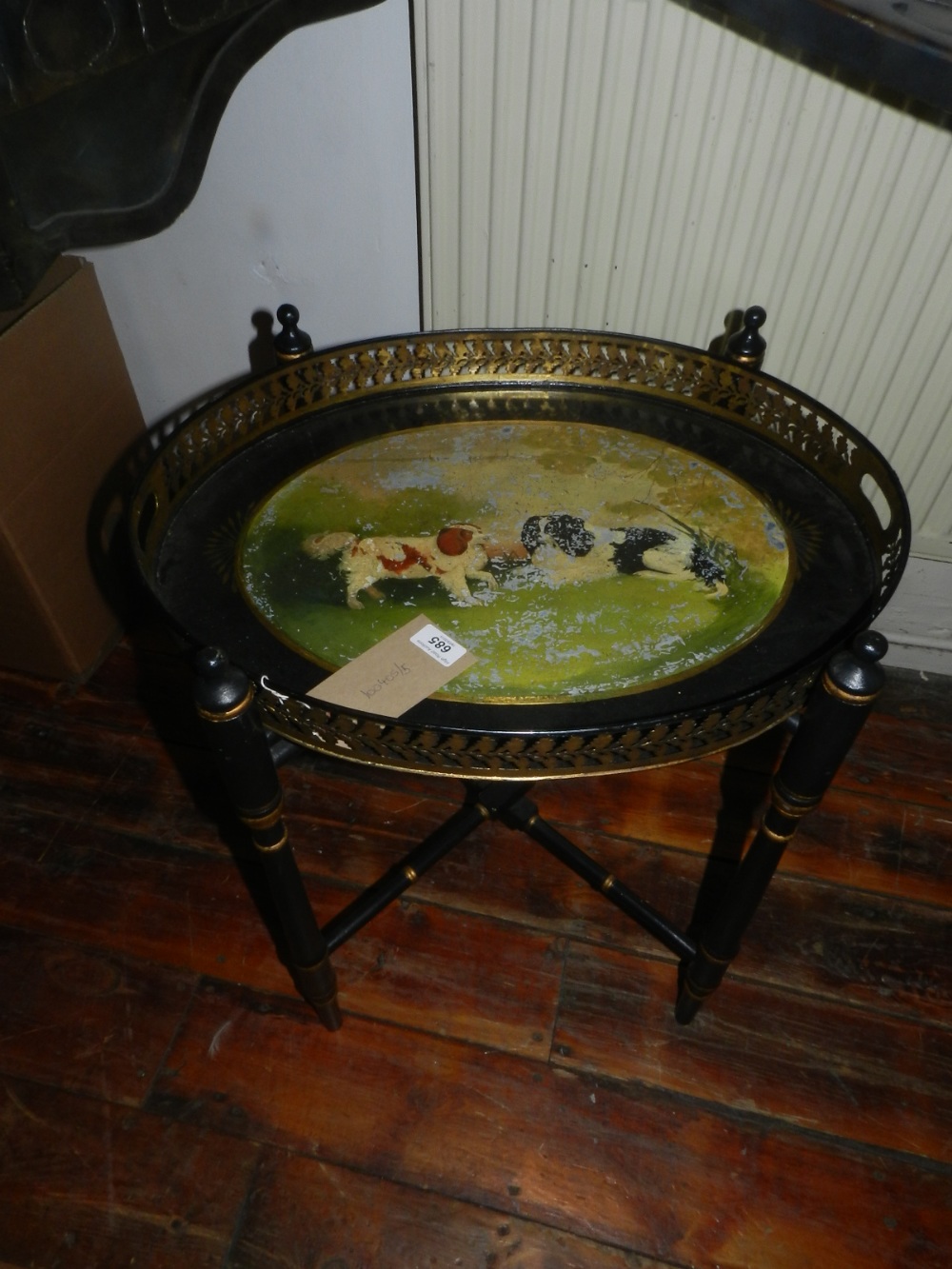 A Victorian oval toleware tea tray, depicting Staffordshire dogs, raised on ebonised stand.