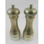 A pair of silver pepper mills, hallmarked London.