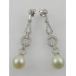 An unusual pair of 18 carat white gold and pearl set articulated drop earrings.