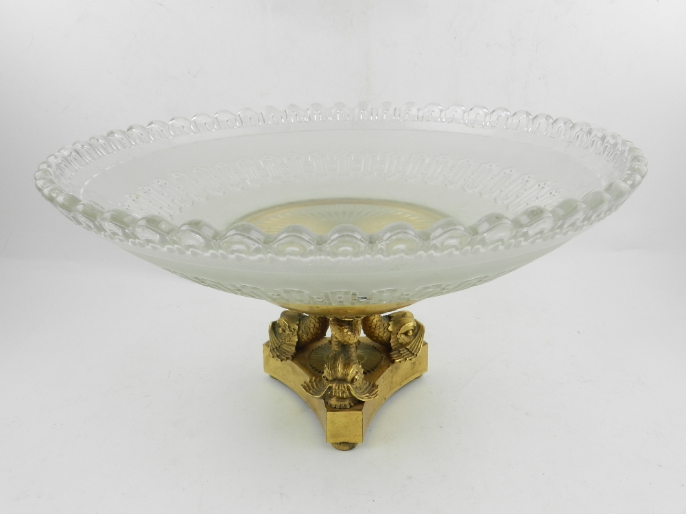 A 19th century ormolu and glass tazza, the ormolu base raised on three dragonfish feet.