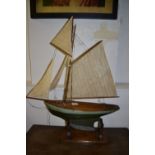 A Victorian pond yacht, with wooden weighted hull, set linen sails. H.93cm