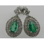 A pair of 18 carat white gold, diamond, and emerald set cluster drop earrings, the pear-cut emeralds