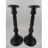 A pair of metal candlesticks, having reeded stems. H.