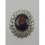 A white metal, diamond, and garnet cluster ring, bears indistinct hallmark to shank.