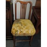 A Victorian upholstered low chair, the padded rail back above a carved splat and overstuffed seat,