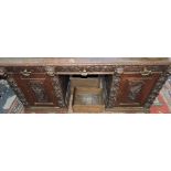 A late 19th Century Flemish carved oak pedestal partners desk,