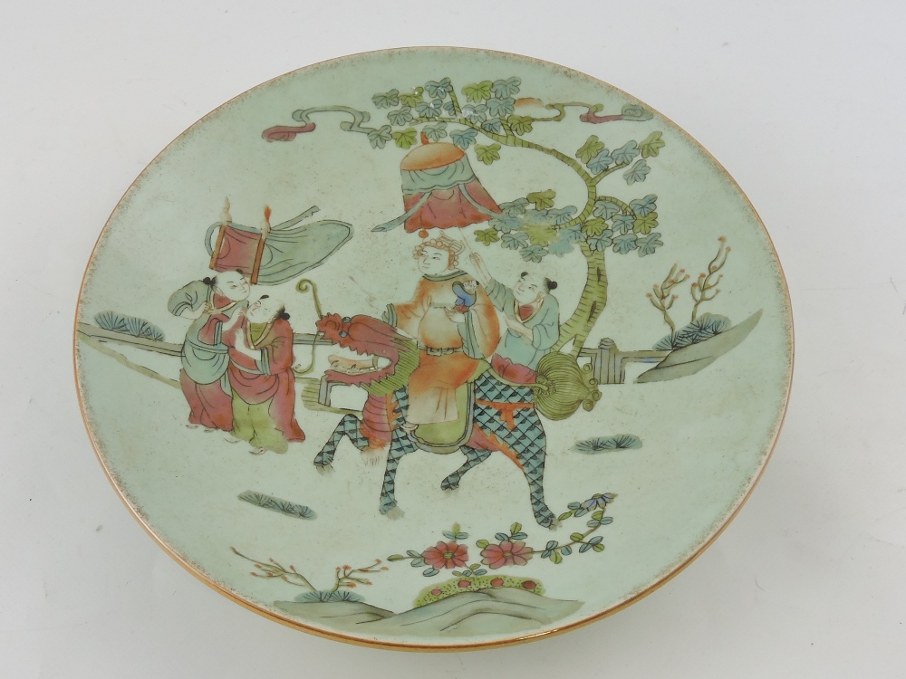 A famille rose dish, decorated with a figures and a dragon in a landscape, with a seal mark to base,
