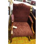 A George III style mahogany library chair, upholstered in patterned burgundy fabric,