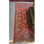 A Belouch red ground rug, woven multiple octagonal hooked medallions, 210cm x 150cm.