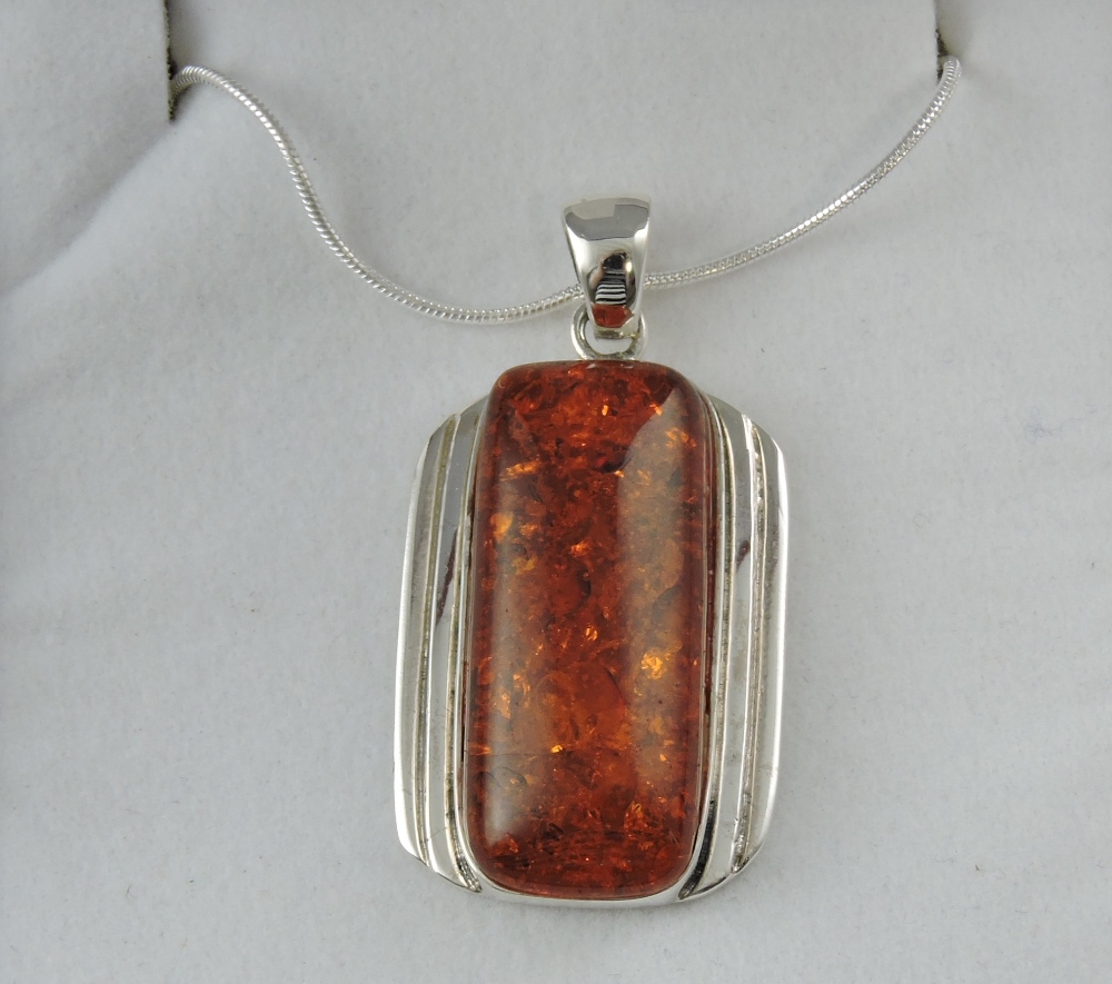 A white metal and amber pendant,