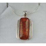 A white metal and amber pendant,