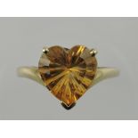 A large heart-shaped citrine dress ring, claw set on a yellow metal band stamped 375, 4g.