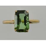 A green tourmaline trap cut dress ring, in a filigree claw setting on a yellow metal band, 3g.