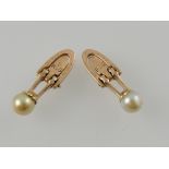 A pair of pearl dress studs, on yellow metal, stamped R&G.