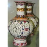A pair of polychrome decorated broad baluster shaped reticulated vases, H. 27cm.
