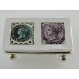 A white metal stamp case, the rectangular hinged lid with enamel plaques showing stamps,