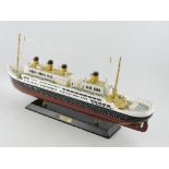 A wooden and polychrome painted desk model of the Titanic, L. 50cm.