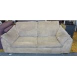 A modern beige fabric two seater sofa.
