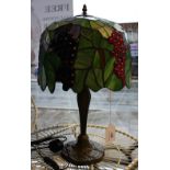 A Tiffany style lamp, the shade leaf decorated with bunches of grapes,