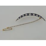 A sapphire and diamond crescent bar brooch, set in white metal with yellow metal backing,