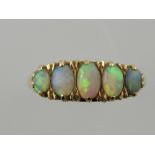 A five stone opal dress ring, claw set in a yellow metal band stamped 18ct.