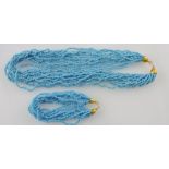 A turquoise coloured multi-strand bead necklace, together with a similar bracelet.