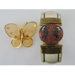 A bone bangle incorporating an enamelled oval box, together with a gilt filigree butterfly, (2).
