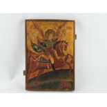 A Russian painted wood icon depicting the Archangel Michael on horseback with trident, 33cm x 23cm.