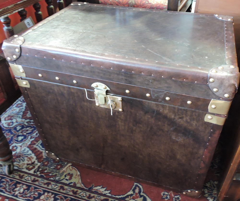 A pair of globetrekker style brass mounted tan leather steamer trunks with strap handles, W. 60cm.