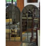 A pair of arched verdigris metal framed wall mirrors, with applied astragal glazing bars, H. 141cm.