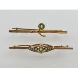 A 9ct gold Arts and Crafts style peridot and seed pearl bar brooch, together with another similar.