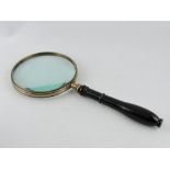 A very large table magnifier, with a turned ebonised wooden handle, lens D. 15cm.