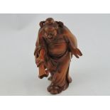 A carved hardwood figure of a Lu Dongbin, modelled with a sword and fly swat, H. 13cm.