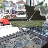 A vintage silver cross coach built child's pram sprung chrome frame with pale green body and dark