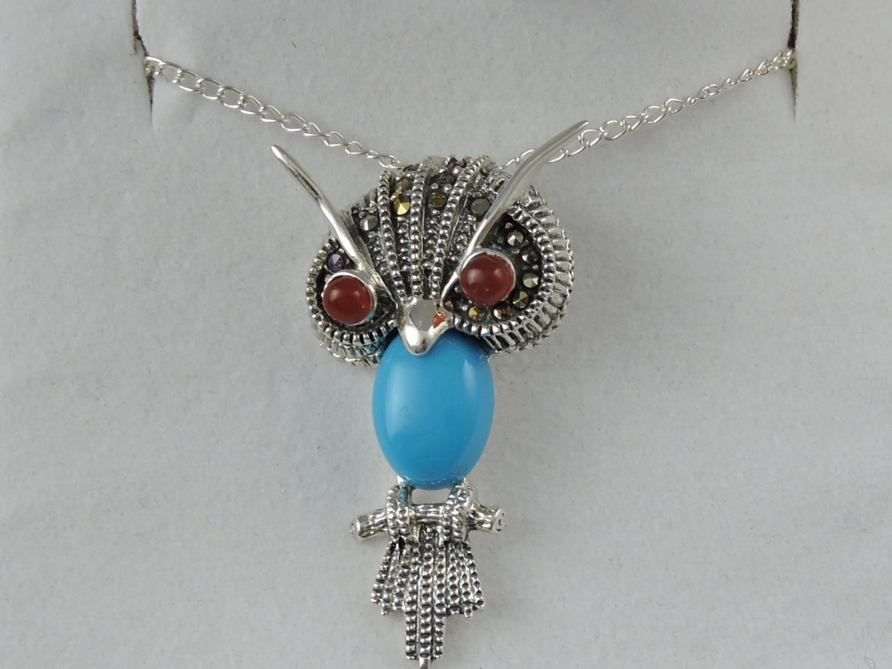 A white metal and turquoise set pendant, in the form of an owl,