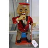 A 1960s Japanese tinplate automaton, modelled as an elderly gentleman smoking a cigar.