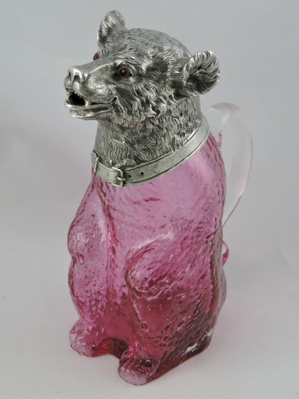 A Victorian style silver-plated and ruby glass claret jug, modelled as a seated bear,