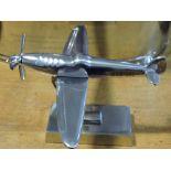 A white metal aircraft desk piece, on a rectangular base, H. 20cm.