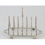 A cast white metal five division toast rack, formed with riding crops and fox head masks, W. 21cm.