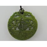 A carved hardstone pendant, modelled with a pair of dragons, D. 7cm.
