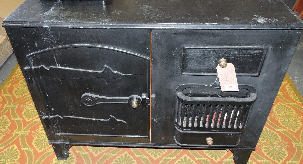 A painted wood two door cabinet modelled as a Victorian cast iron range, W. 97cm.