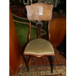 An Art Nouveau mahogany chair, having a green upholstered seat and marquetry inlaid backrest.